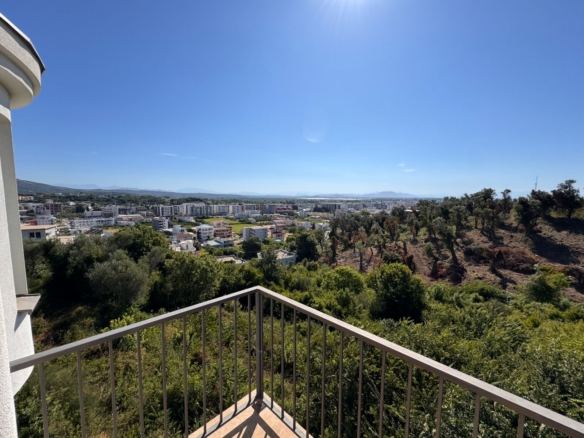 Prime balcony view of Ulcinj, Montenegro—lush hills, cityscape, sunlit skies. Invest via montenegro-listings.me by Ekosphere doo.