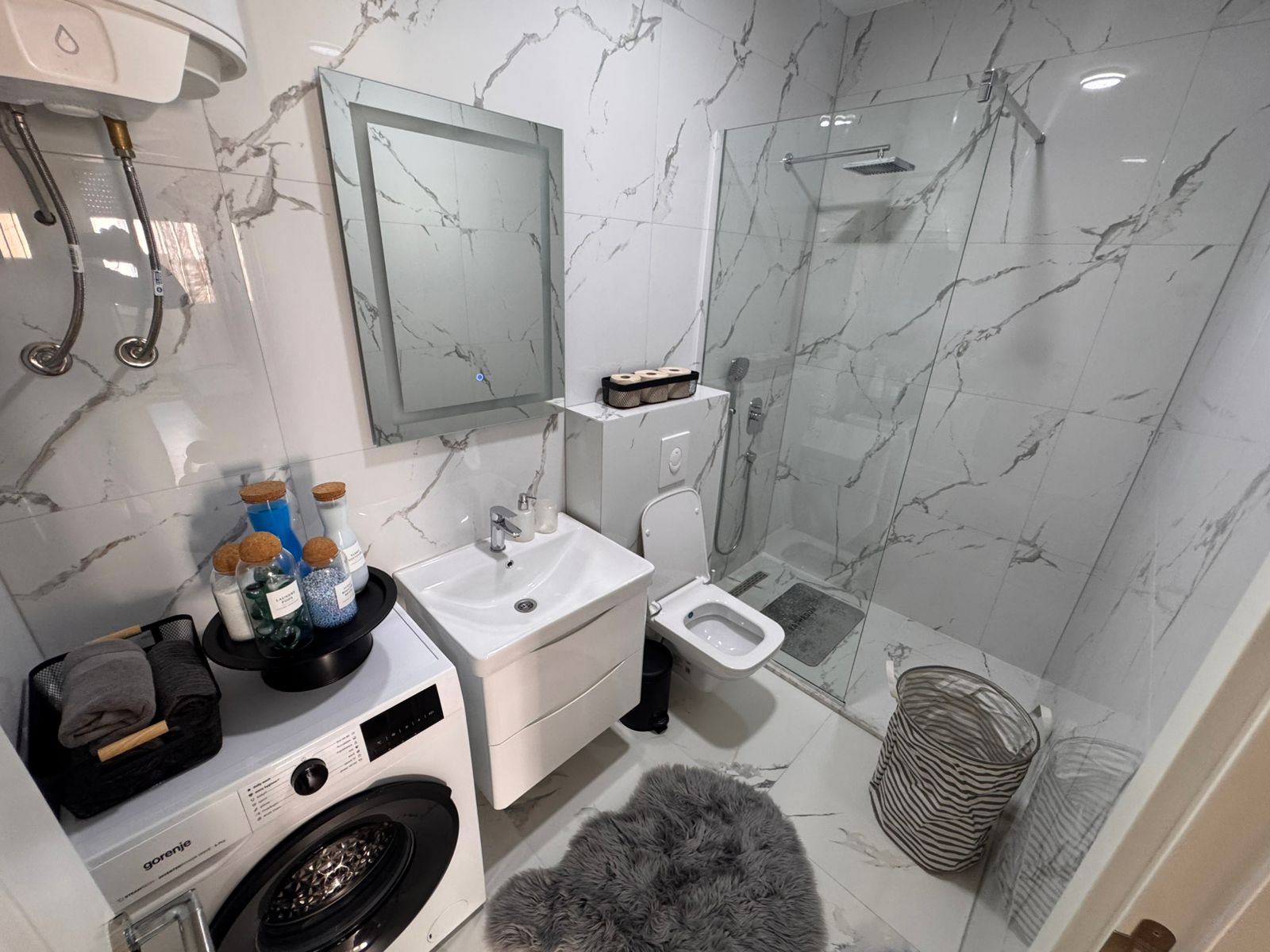 Luxurious Ulcinj Montenegro property: sleek marble-tiled bathroom, glass shower, amenities. Invest via montenegro-listings.me/Ekosphere DOO.
