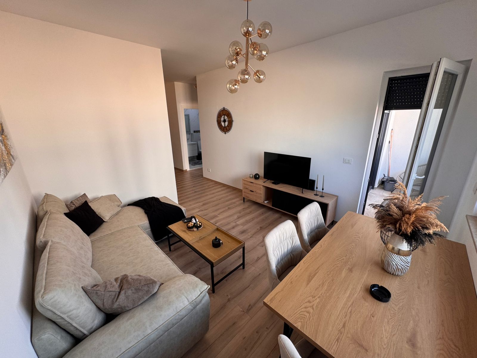 Modern Ulcinj living room with beige sofa, dining area, balcony access; prime property on montenegro-listings.me by Ekosphere DOO.