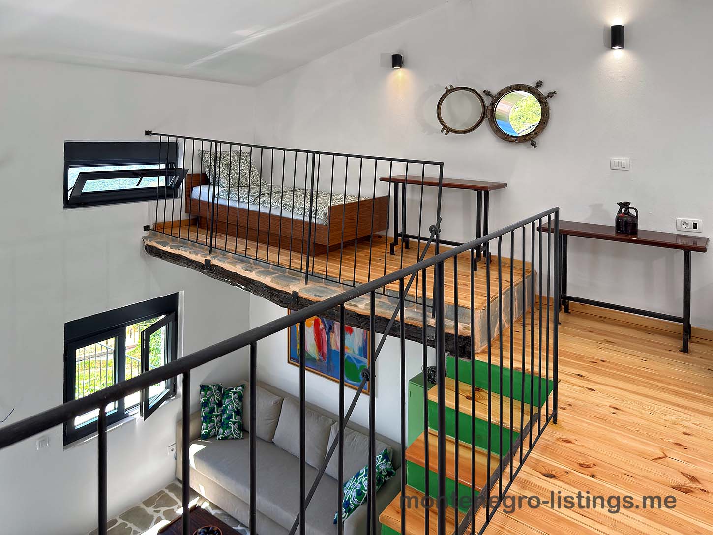 Modern loft bedroom with wood floors, metal railing, and dual mirrors, ideal Ulcinj investment at montenegro-listings.me by ekosphere doo.