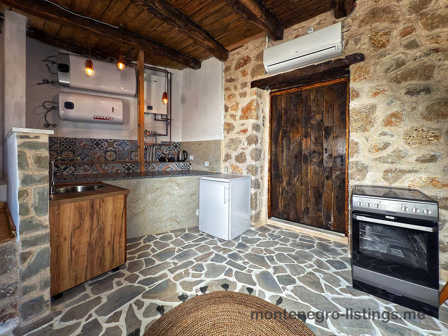 Charming rustic kitchen in Ulcinj with stone floors, wood ceiling, classic amenities&mdash;ideal Montenegro investment by Ekosphere on montenegro-listings.me.
