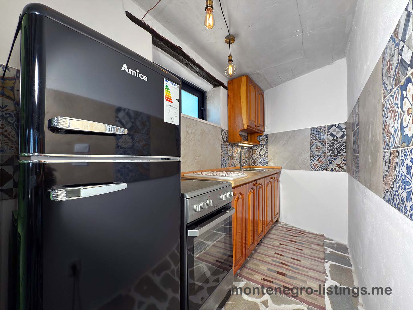 Modern Ulcinj kitchen: sleek Amica appliances, stylish tiles, wood cabinets&mdash;ideal Montenegro property. Listed on montenegro-listings.me by ekosphere doo.