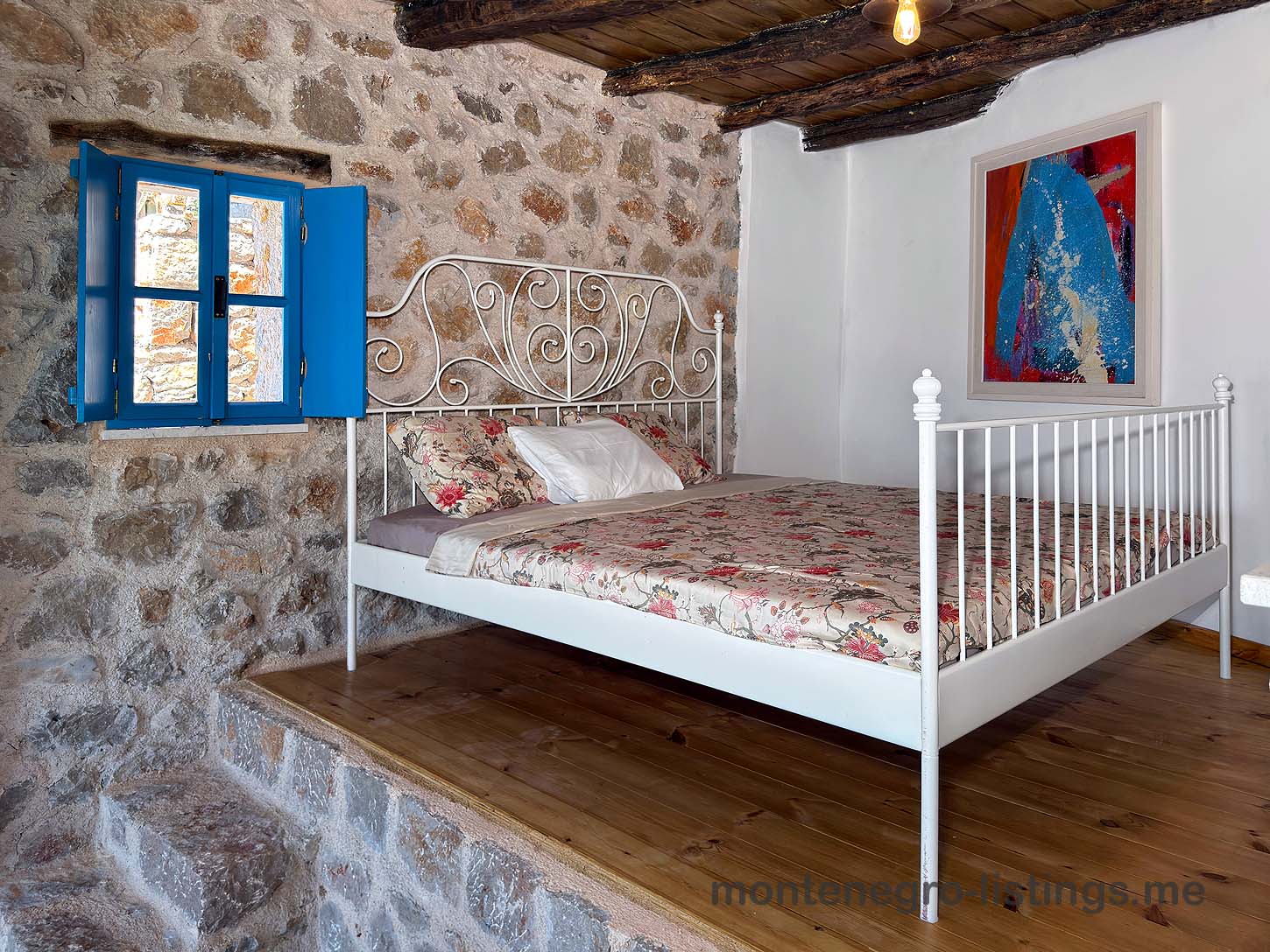 Charming Ulcinj property: stone-walled room, stylish white bed, wood platform&mdash;invest in Montenegro with montenegro-listings.me by ekosphere doo.