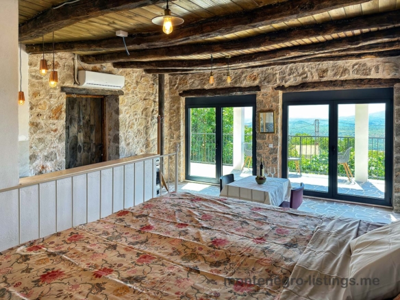 Charming Ulcinj retreat: exposed beams, stone walls, floral décor, patio with hillside views. Invest via montenegro-listings.me by ekosphere doo.