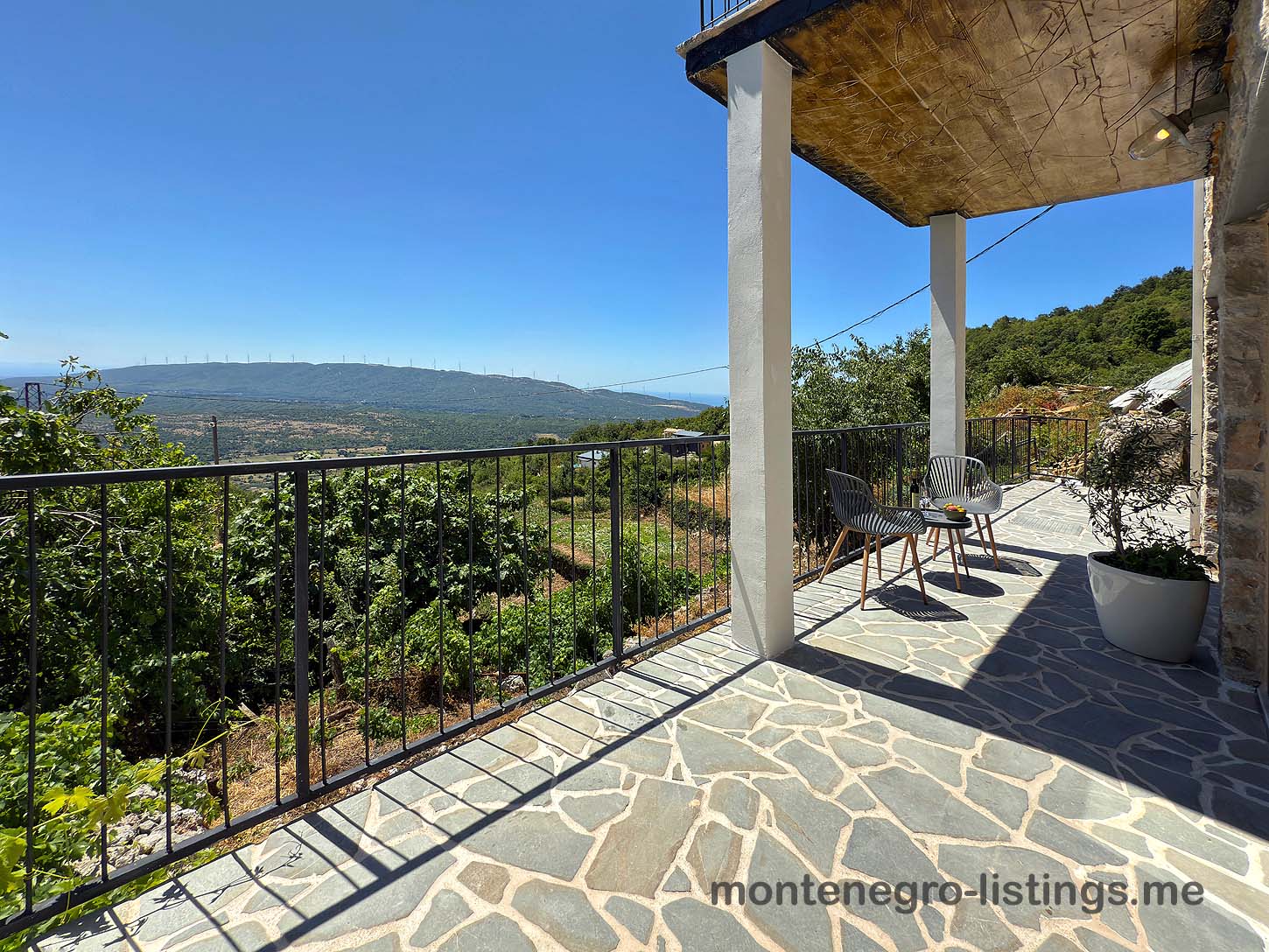Elegant stone patio with metal railing, panoramic Ulcinj valley views&mdash;prime Montenegro real estate by ekosphere doo at montenegro-listings.me.