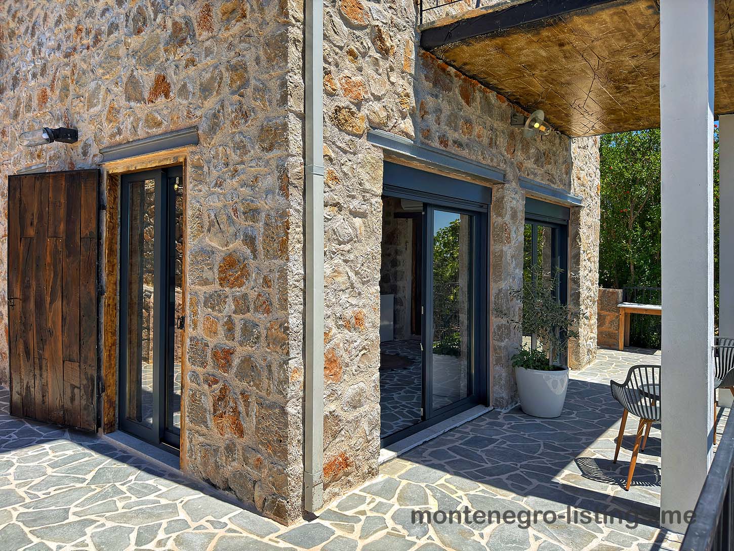 Modern Ulcinj stone corner home with sliding glass doors, patio, and mountain views&mdash;exclusive Ekosphere DOO investment via montenegro-listings.me.