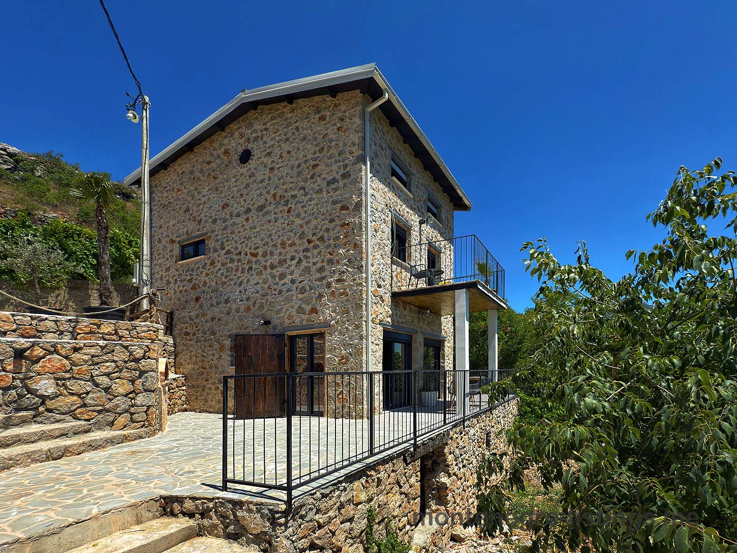 Discover this stunning two-story Ekosphere stone house in Ulcinj, Montenegro with large windows and a raised patio&mdash;exclusive at montenegro-listings.me, a project by Ekosphere doo.