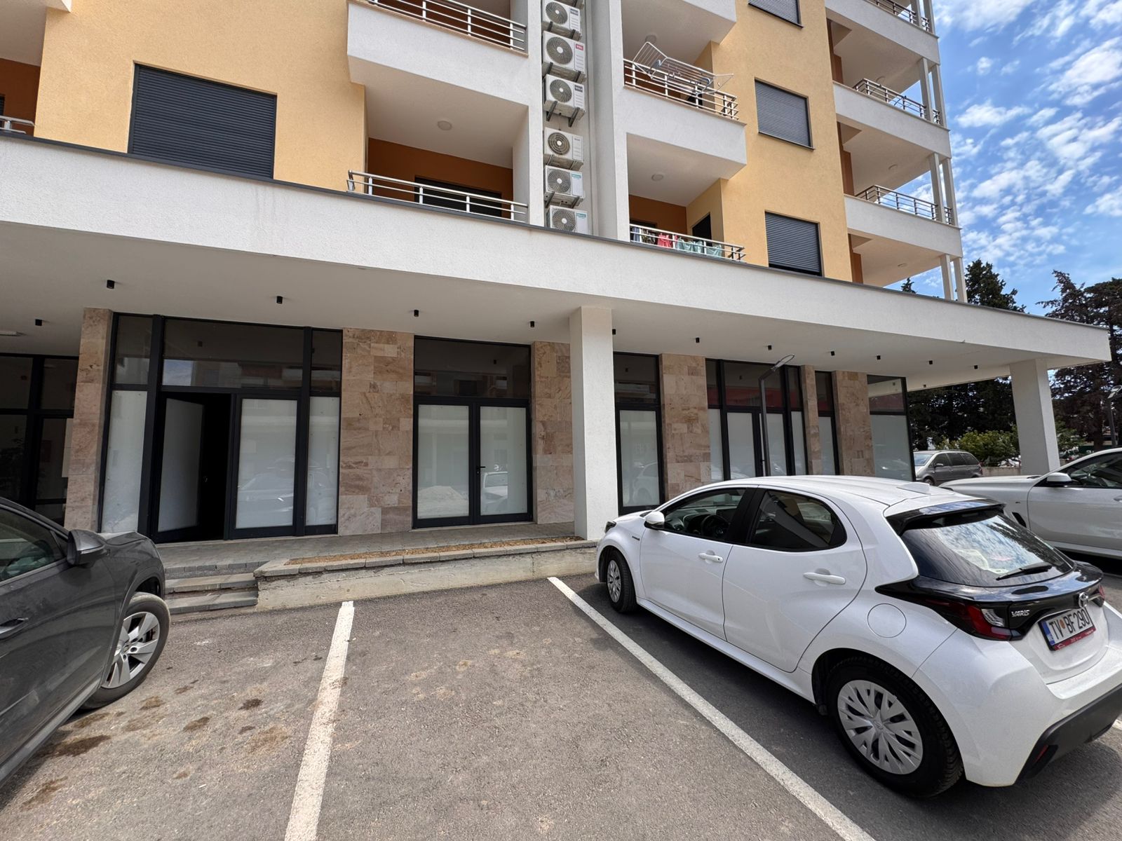 Modern multi-story building in Ulcinj, Montenegro with large windows and AC units&mdash;exclusive real estate by Ekosphere, montenegro-listings.me.