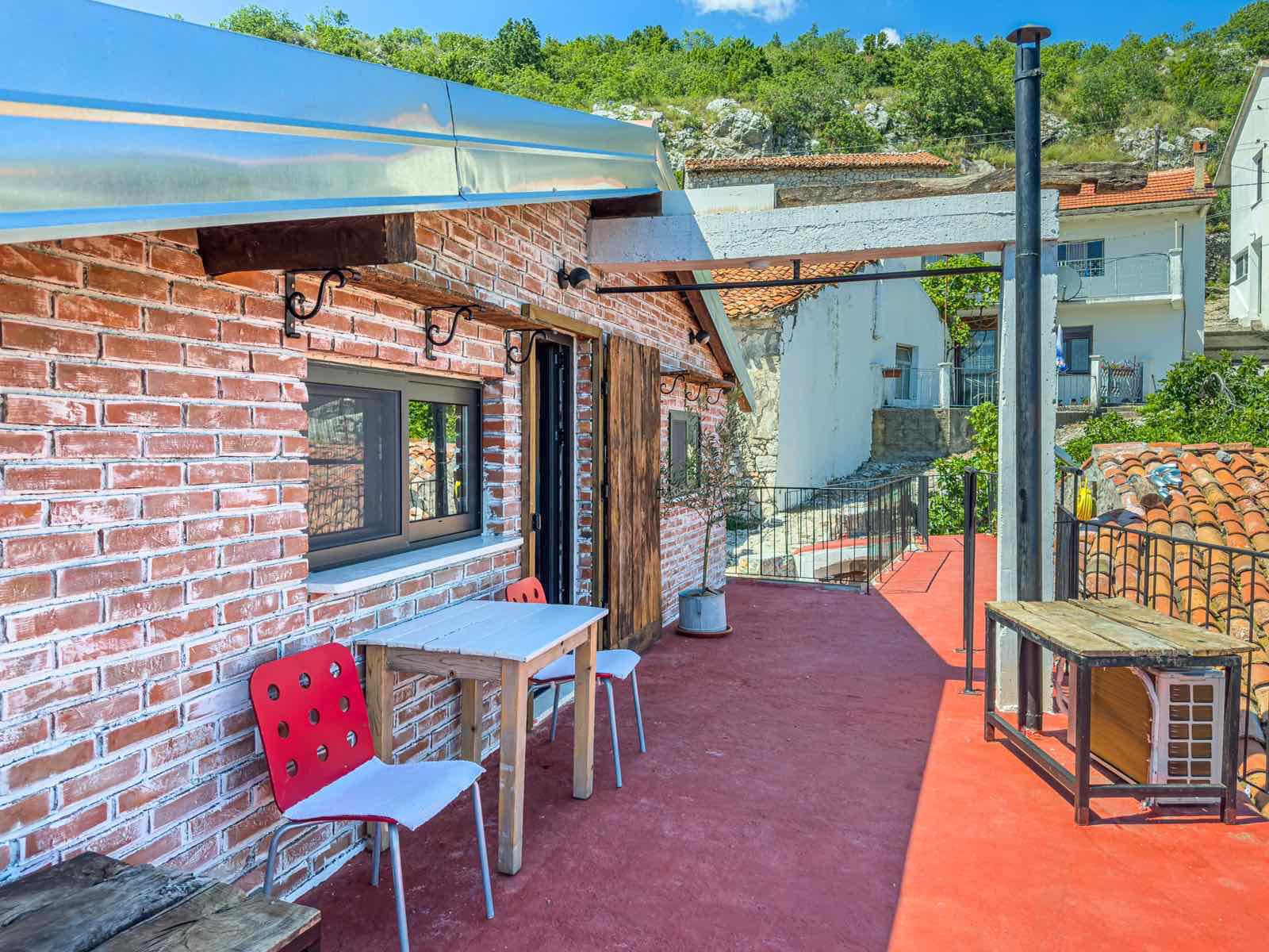 Stunning Ulcinj rooftop terrace with red flooring, greenery, city views—ideal Montenegro investment at montenegro-listings.me by ekosphere doo.