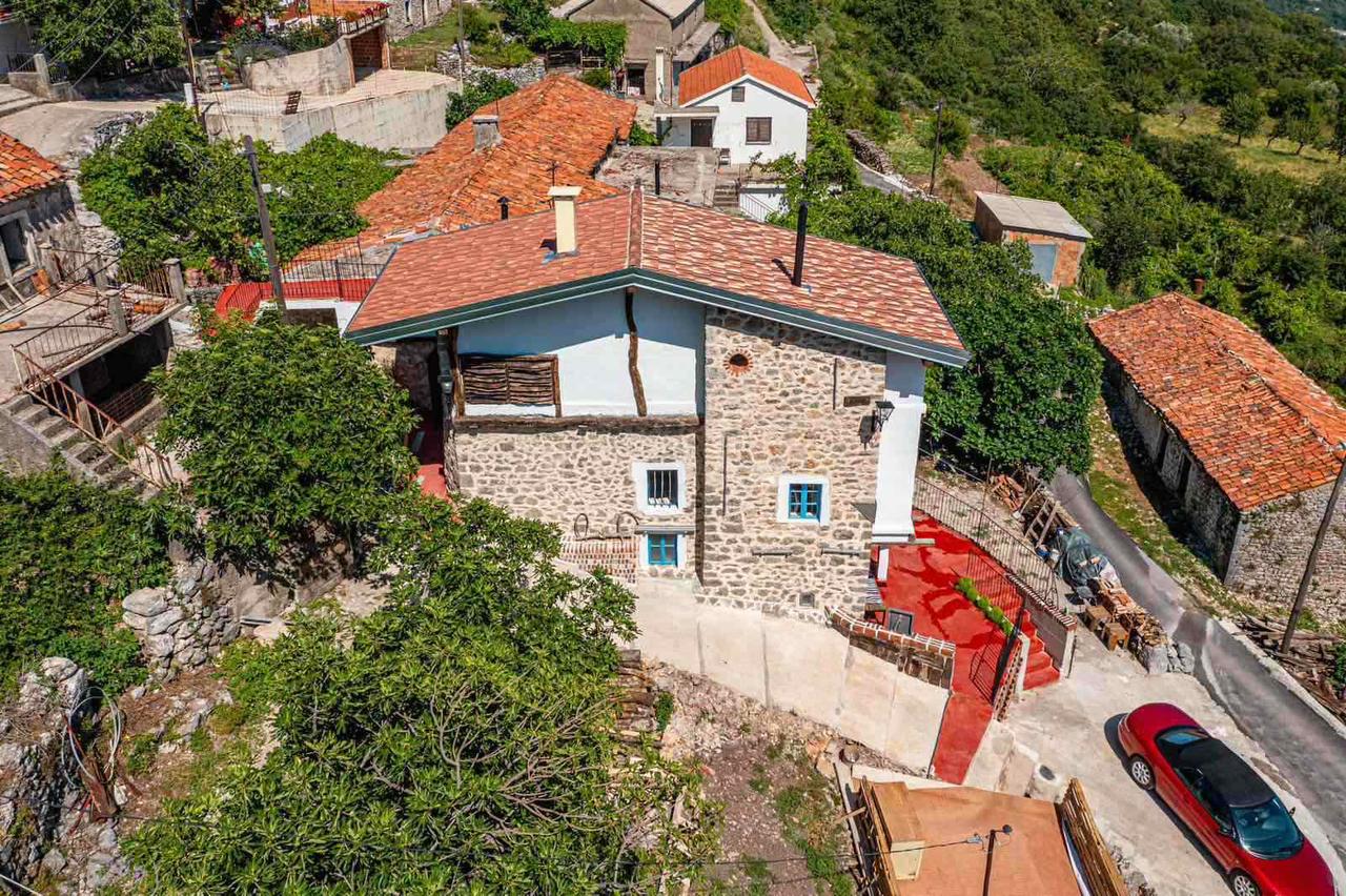 Ulcinj Real Estate Discover a traditional stone house with red-tiled roof in hilly, green Ulcinj—prime real estate on montenegro-listings.me by ekosphere doo.