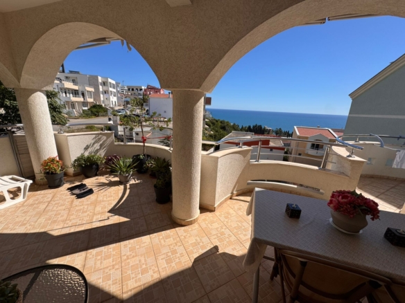 Spacious tiled balcony in Ulcinj with sea view, stylish columns, lush potted plants—exclusive property by montenegro-listings.me.