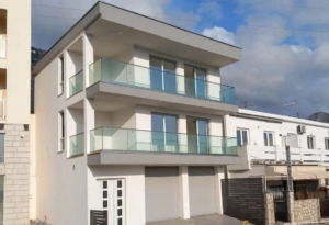 Luxurious three-story white residence in Ulcinj with glass balconies, double garage, prime investment, offered by montenegro-listings.me.