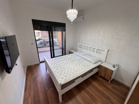 Modern Ulcinj bedroom with double bed, AC, TV, chandelier, and balcony access—prime real estate by montenegro-listings.me/Ekosphere doo.