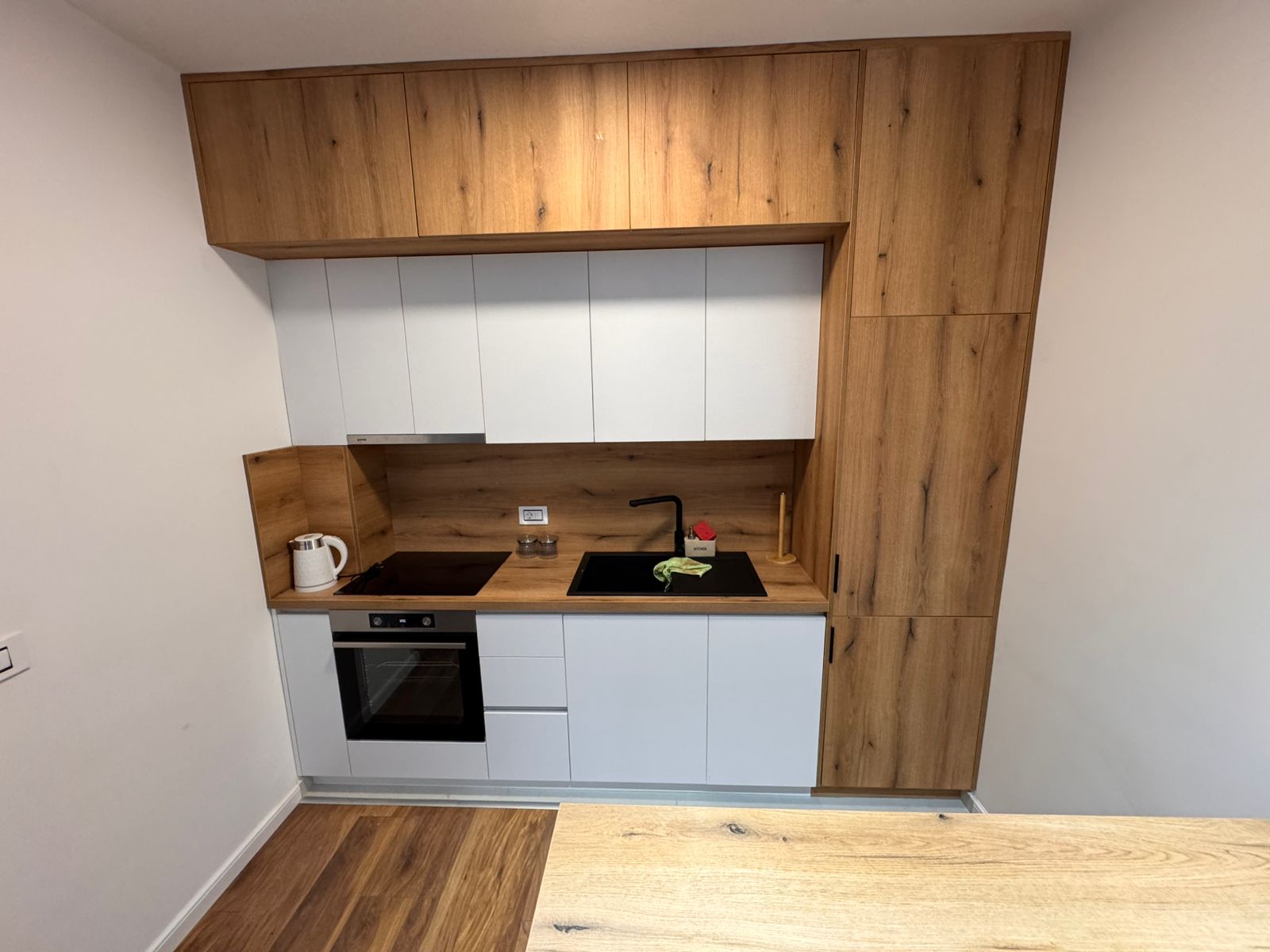 Stylish Ulcinj kitchen: wood & white cabinets, built-in oven, modern finishes—exclusive to montenegro-listings.me by ekosphere doo.