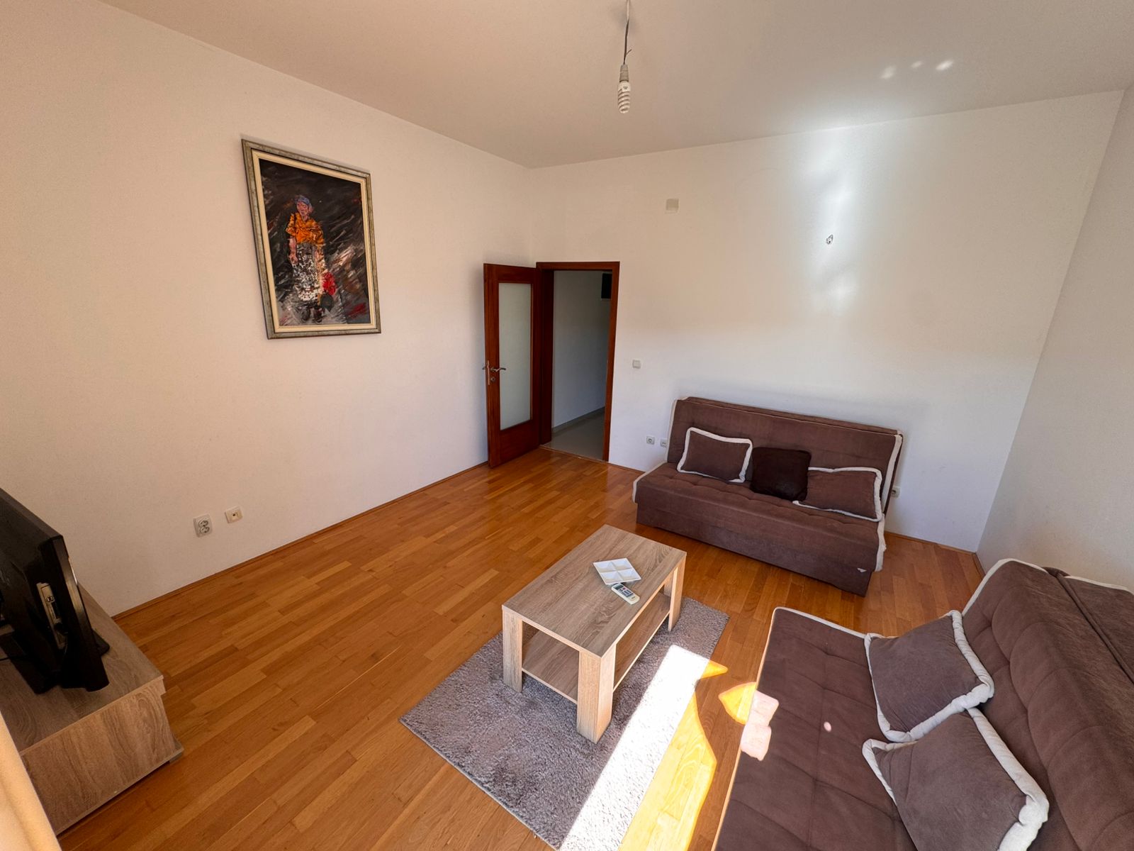 Bright Ulcinj living room with light wood floors, modern brown sofas, and stylish décor. Exclusive at montenegro-listings.me by ekosphere doo.