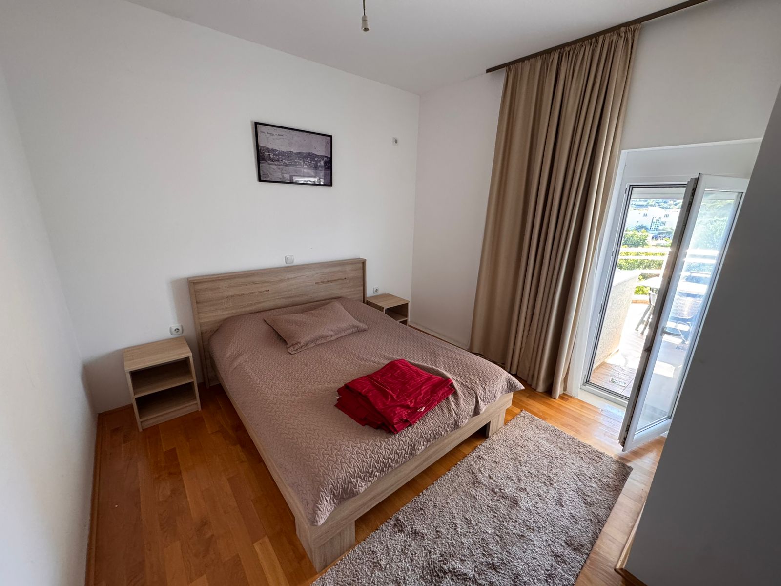 Elegant, modern Ulcinj bedroom with double bed, balcony access, and stylish details&mdash;prime Montenegro real estate by ekosphere doo.