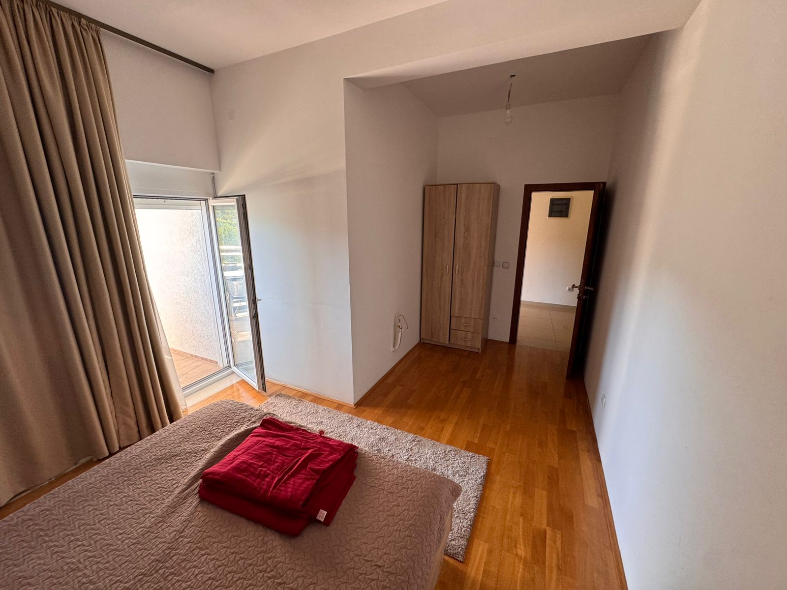 Spacious Ulcinj bedroom with double bed, balcony access, modern wardrobe, and quality wooden floors&mdash;exclusive at montenegro-listings.me by ekosphere doo.