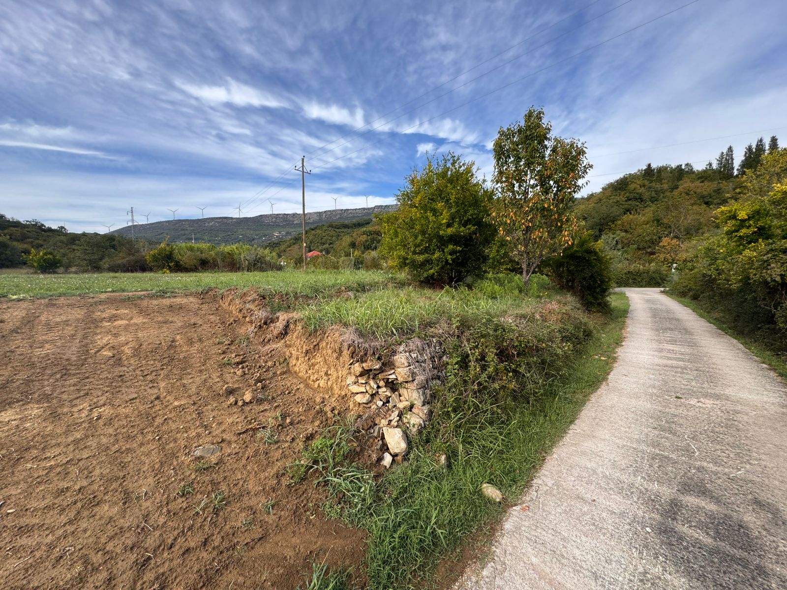 Premium Ulcinj land: paved road access, lush greenery, tilled fields & wind turbines&mdash;exclusive at montenegro-listings.me by ekosphere doo.