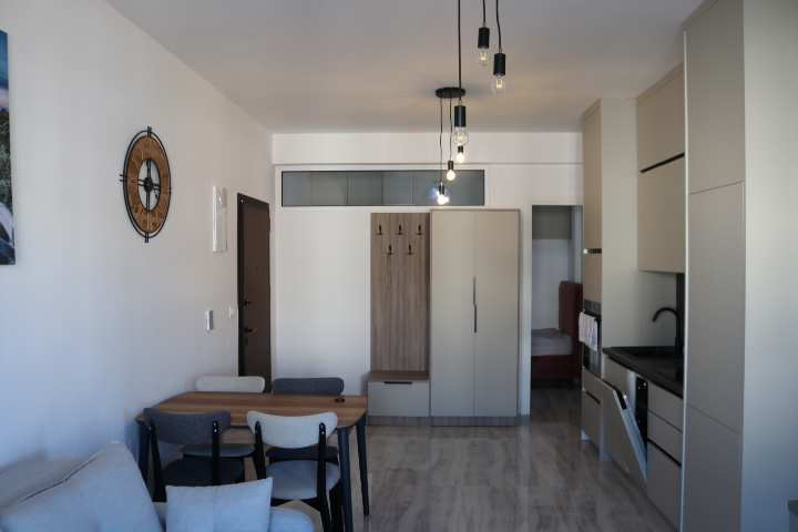 Stylish Ulcinj studio apartment with dining area, modern kitchen, cozy sofa, alcove bed. Invest in Montenegro at montenegro-listings.me by ekosphere doo.