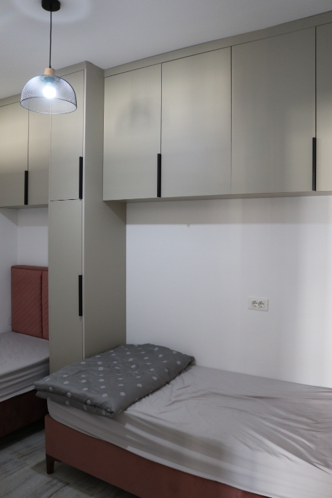 Modern Ulcinj bedroom with two single beds, built-in cabinets, stylish bedding; ideal Montenegro investment by ekosphere doo.