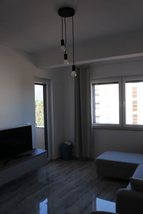 Stylish, modern Ulcinj living room with large windows, gray sectional, and chic lighting—top property at montenegro-listings.me by ekosphere doo.