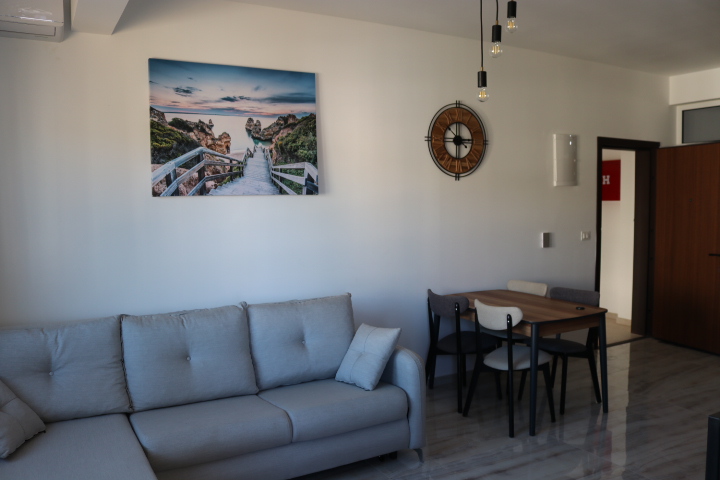 Bright, modern living room in Ulcinj with a light gray sofa, dining area, stylish decor—exclusive at montenegro-listings.me by ekosphere doo.