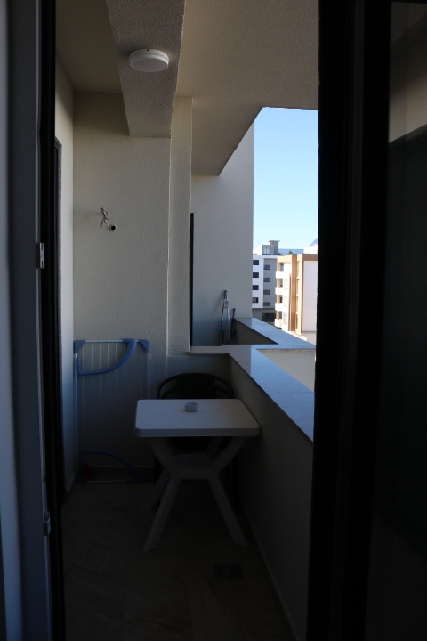 Charming Ulcinj balcony with white table, chair, and drying rack. Enjoy blue sky views—exclusive listing by ekosphere doo on montenegro-listings.me.