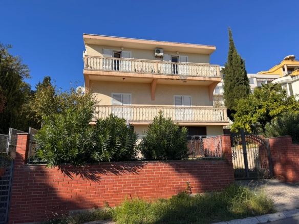 Premium three-story beige house in Ulcinj with 2 balconies, lush greenery, brick fence. Top Montenegro investment at montenegro-listings.me by ekosphere doo.