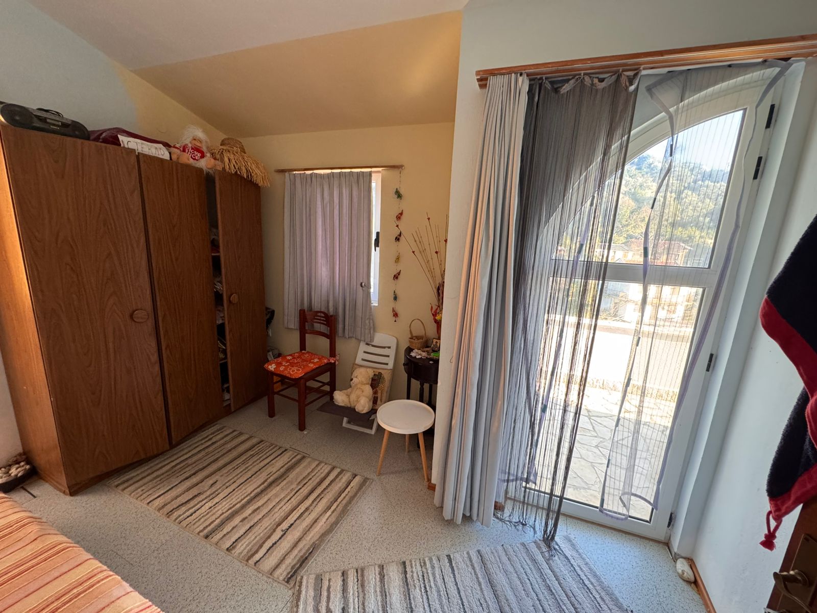 Bright Ulcinj bedroom with wardrobe, cozy balcony access, modern rugs; ideal Montenegro investment listed on montenegro-listings.me.