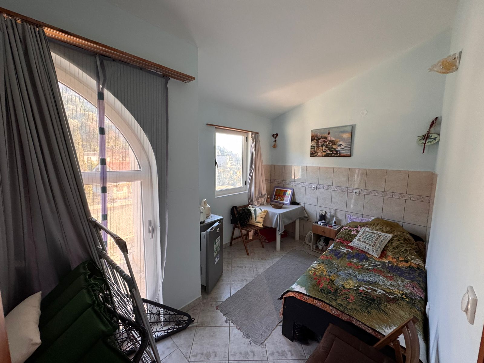Bright, well-appointed Ulcinj bedroom with single bed, desk, mini fridge, lounge chair. Ideal Montenegro investment via ekosphere doo.