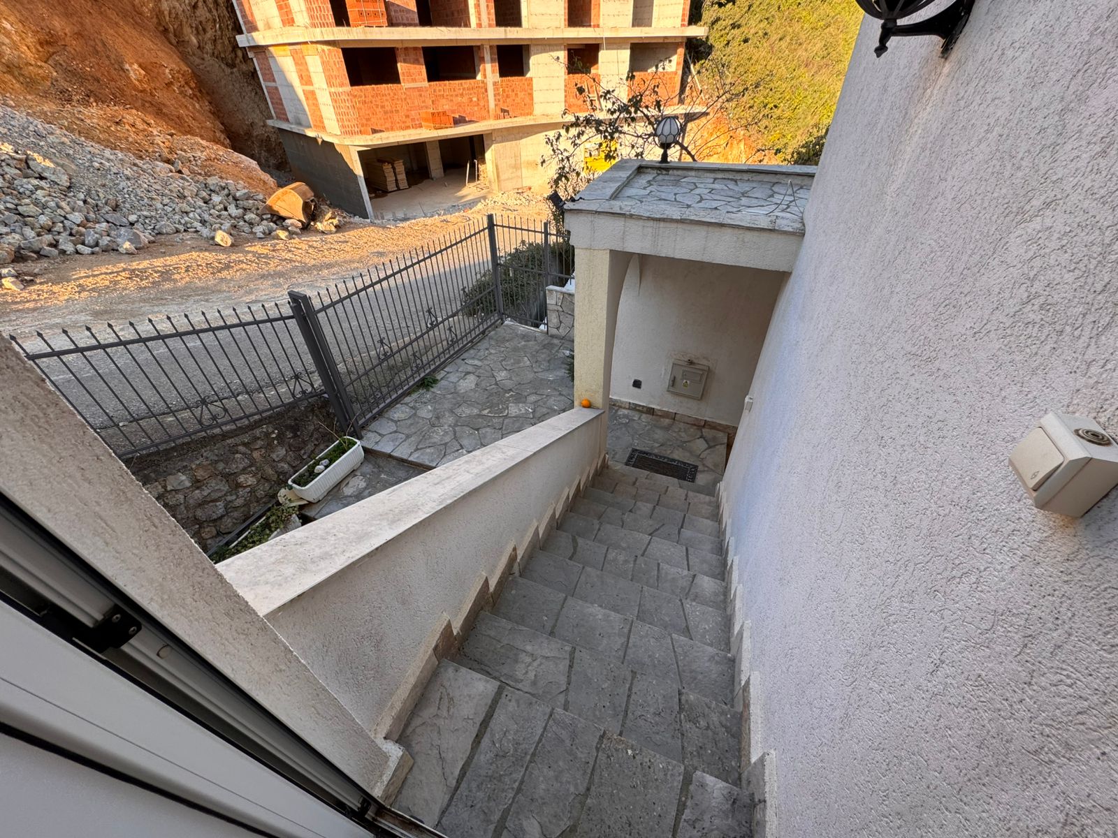 Elegant stone staircase descends to gated entry, overlooking new development potential in Ulcinj. Exclusive on montenegro-listings.me by ekosphere doo.