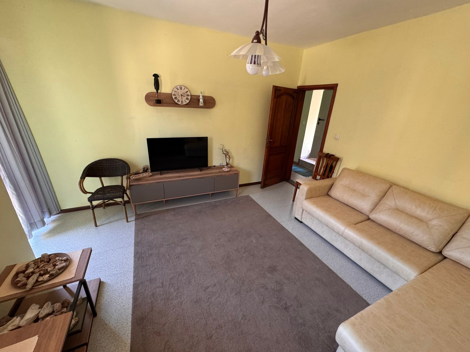 Stylish Ulcinj living room: beige walls, modern tan sectional, TV, decor accents&mdash;prime Montenegro investment at montenegro-listings.me.