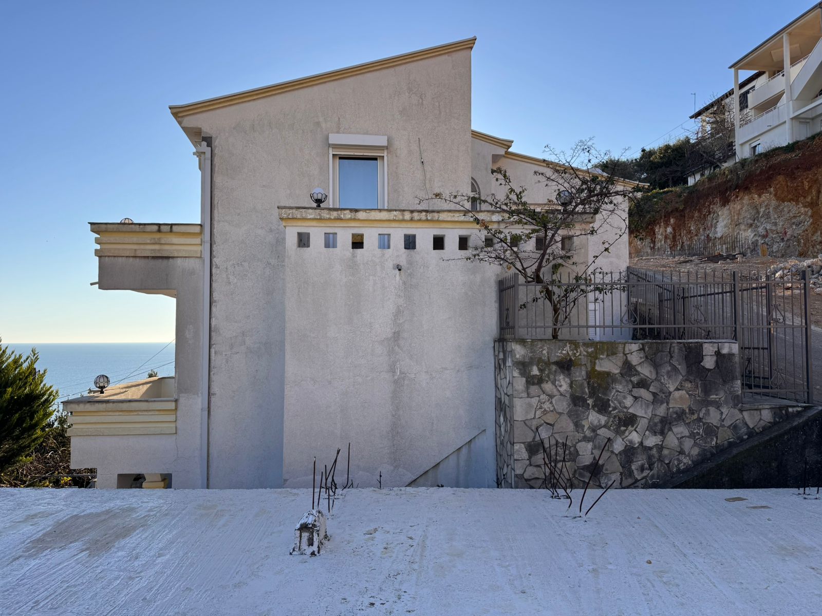 Modern two-story white home with a flat roof, sea views, driveway, and stone wall&mdash;prime Ulcinj investment on montenegro-listings.me.
