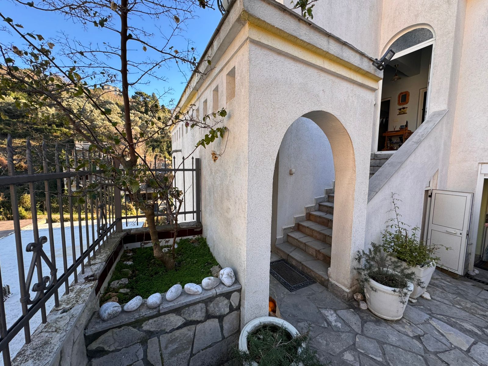 Prime Ulcinj property: Elegant white residence with arched entry, stone steps, garden, and secure fence. Invest via montenegro-listings.me by ekosphere doo.
