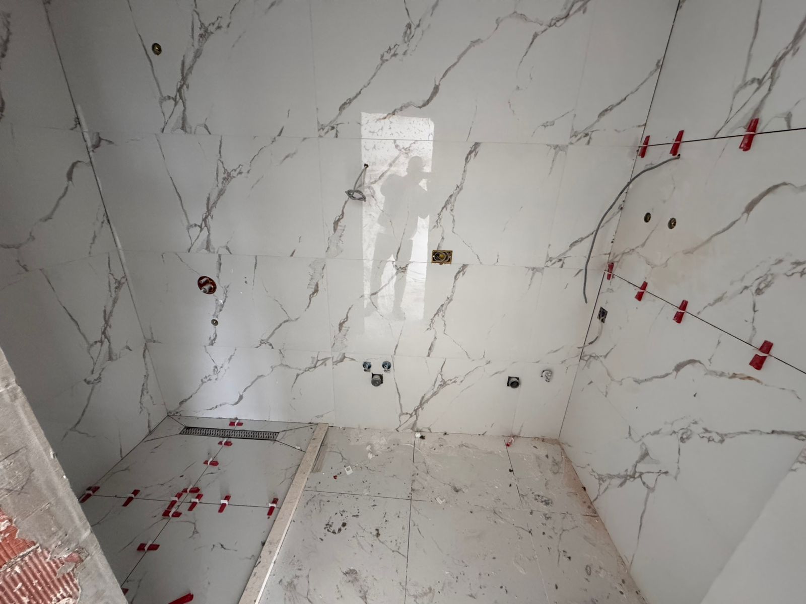 Under-construction bathroom in Ulcinj with elegant marble-effect tiles, ideal investment. Listed on montenegro-listings.me by Ekosphere doo.