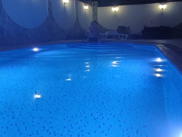 Stunning Ulcinj villa: illuminated pool, elegant stone walls, luxe lounge chair. Invest in Montenegro with montenegro-listings.me.