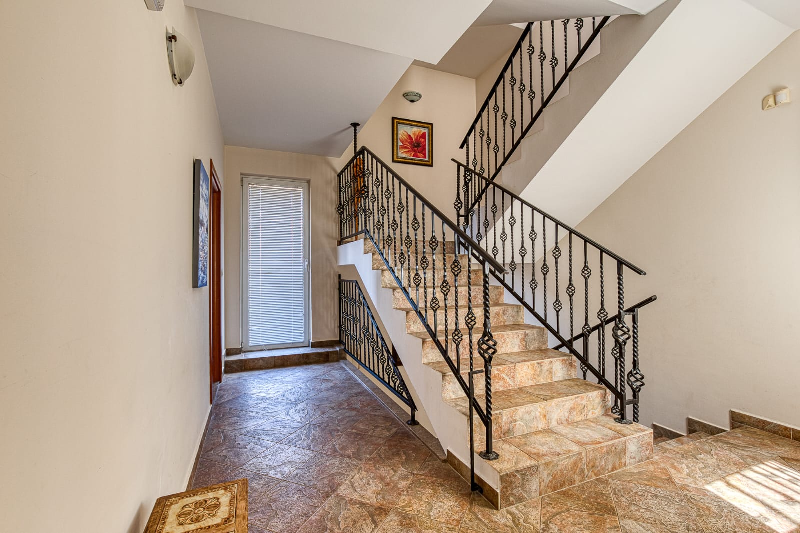 Elegant staircase with brown tiles, black railings, and stylish hallway&mdash;ideal Ulcinj investment! montenegro-listings.me by ekosphere doo.