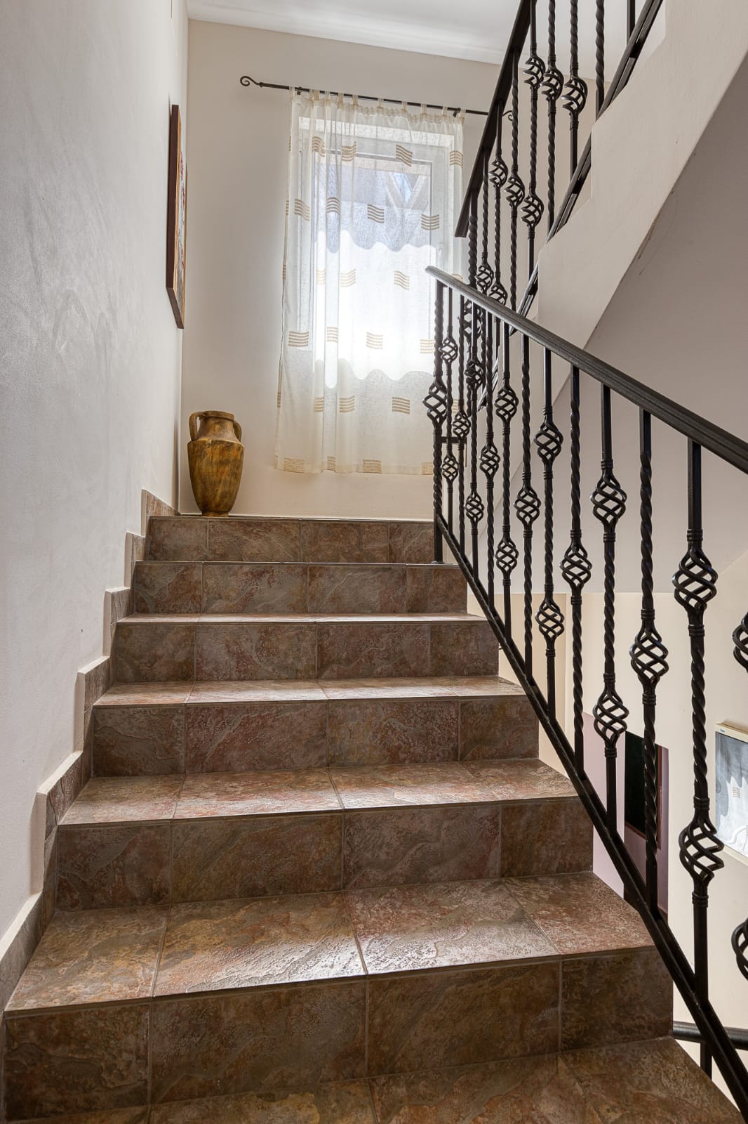 Elegant tiled staircase with modern railings, natural light, and upscale d&eacute;cor&mdash;prime Ulcinj real estate by montenegro-listings.me.