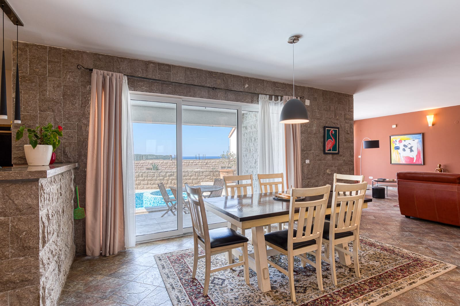 Elegant dining area with stone walls, pool views, and open-plan living&mdash;prime Ulcinj property via montenegro-listings.me by ekosphere doo.