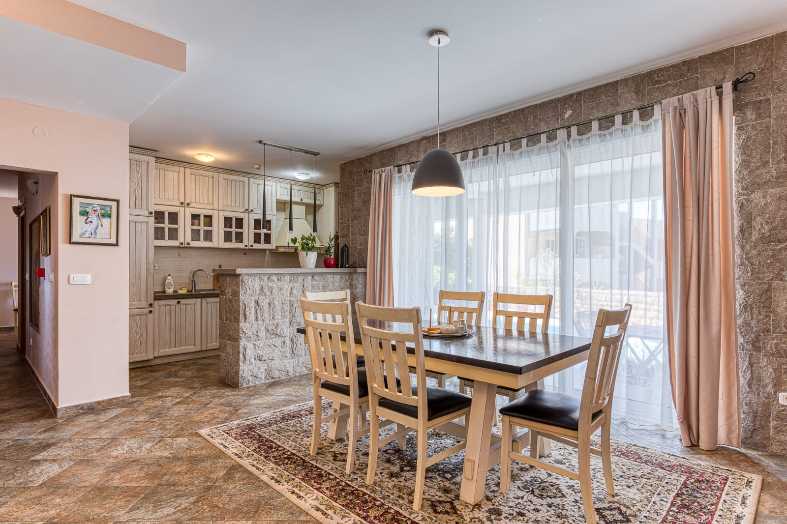 Modern Ulcinj apartment: spacious dining with wooden table, stylish kitchen, sunlit windows&mdash;ideal Montenegro investment. Eksophere doo.