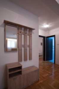 Elegant hallway in Ulcinj property with parquet floors, modern coat rack, ample storage, and access to spacious rooms. Eksosphere DOO project.