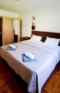 Stylish Ulcinj bedroom with double bed, quality linens, modern wardrobe & decor—ideal Montenegro investment via montenegro-listings.me.