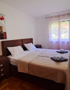 Modern double bedroom in Ulcinj with elegant beige bedding, natural light, and stylish decor—exclusive at montenegro-listings.me by ekosphere doo.