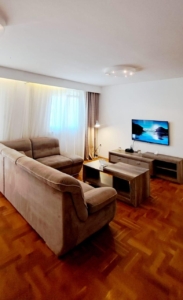 Stylish Ulcinj apartment: modern living room, parquet floors, L-shaped sofa, ideal investment. Listing by ekosphere doo on montenegro-listings.me.