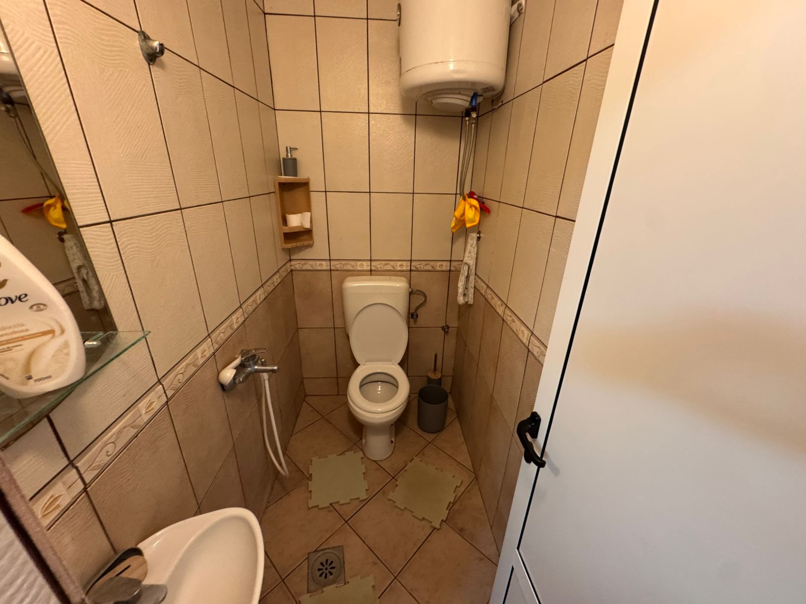 Modern tiled bathroom with toilet, sink, mirror, water heater—ideal Ulcinj Montenegro investment. Listed by ekosphere doo.