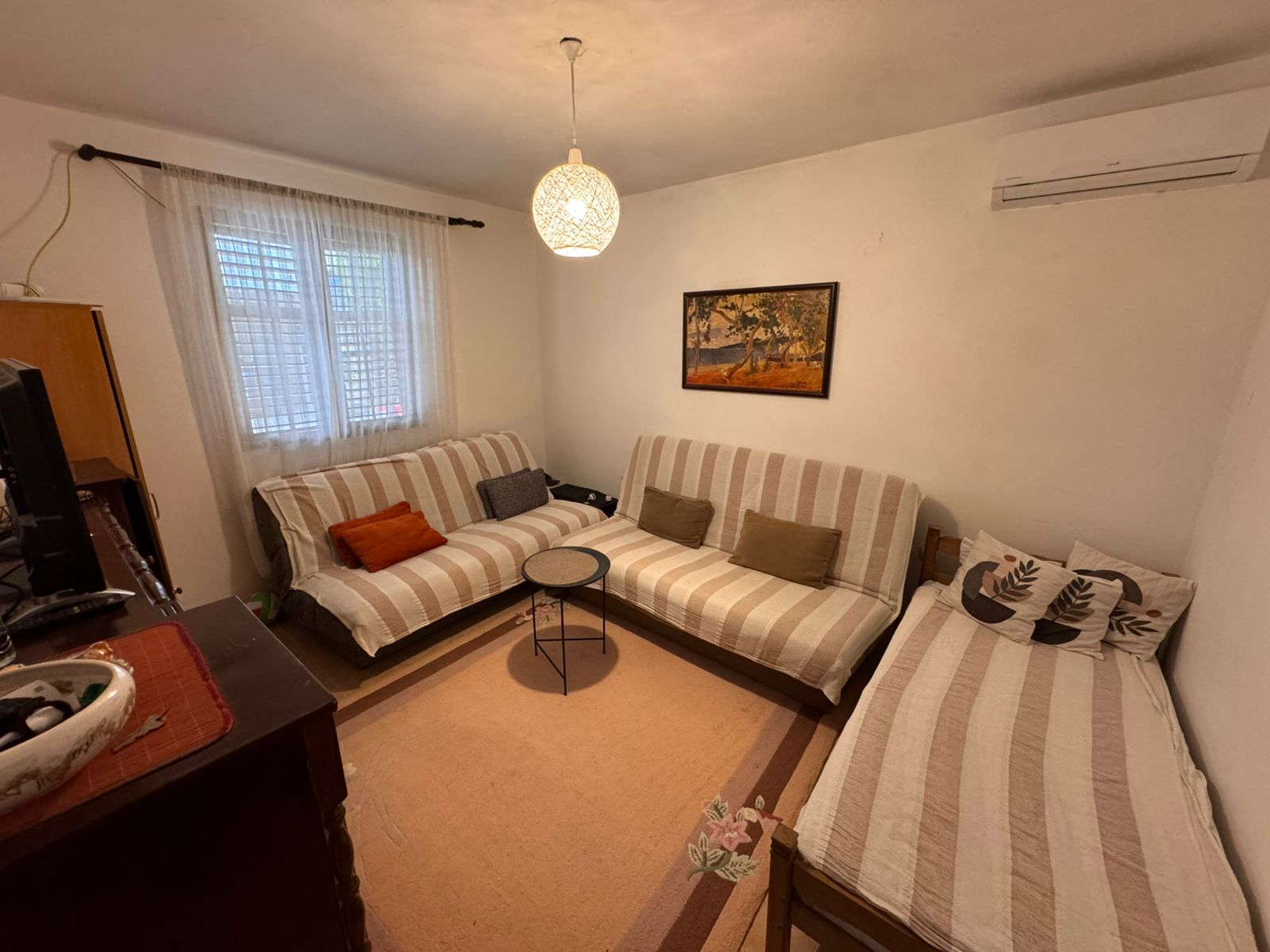 Charming Ulcinj living room: striped sofas, daybed, AC, TV, chic décor—invest in Montenegro at montenegro-listings.me by ekosphere doo.