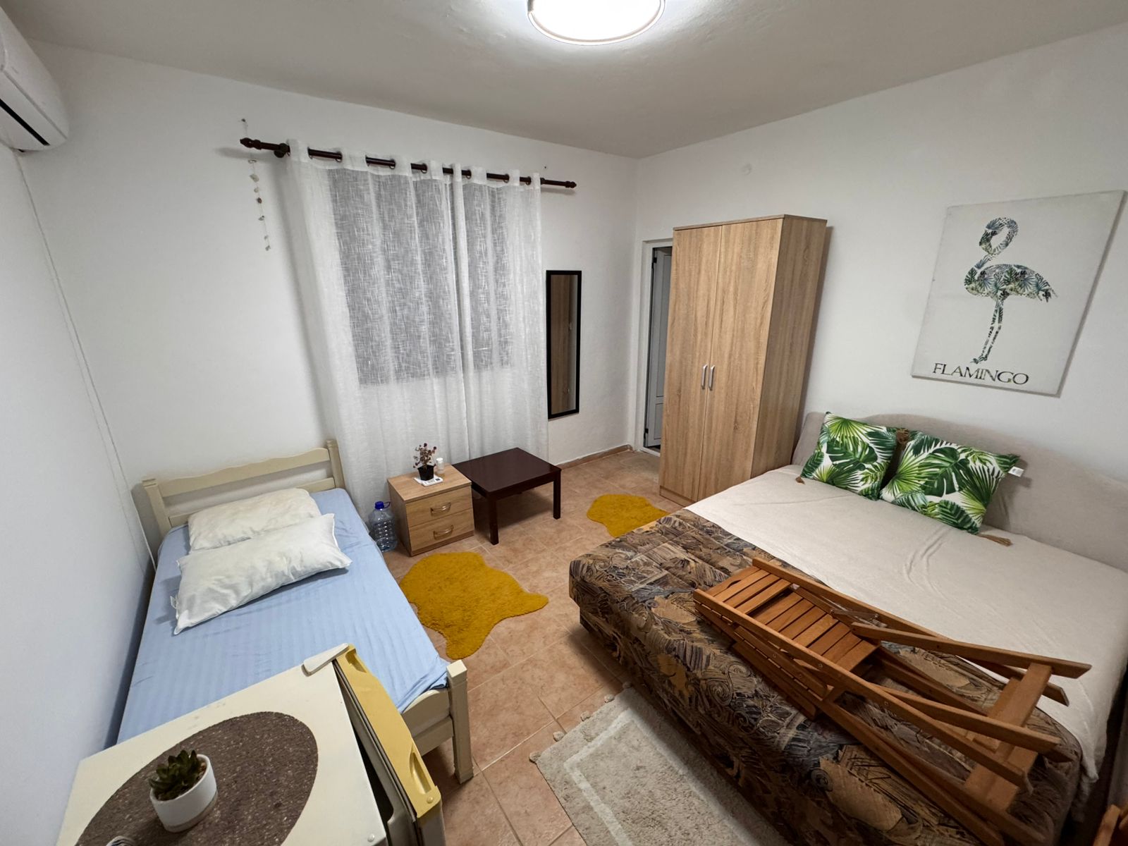Charming Ulcinj bedroom: single & double beds, modern wardrobe, cozy rugs, stylish decor. Ideal investment on montenegro-listings.me.