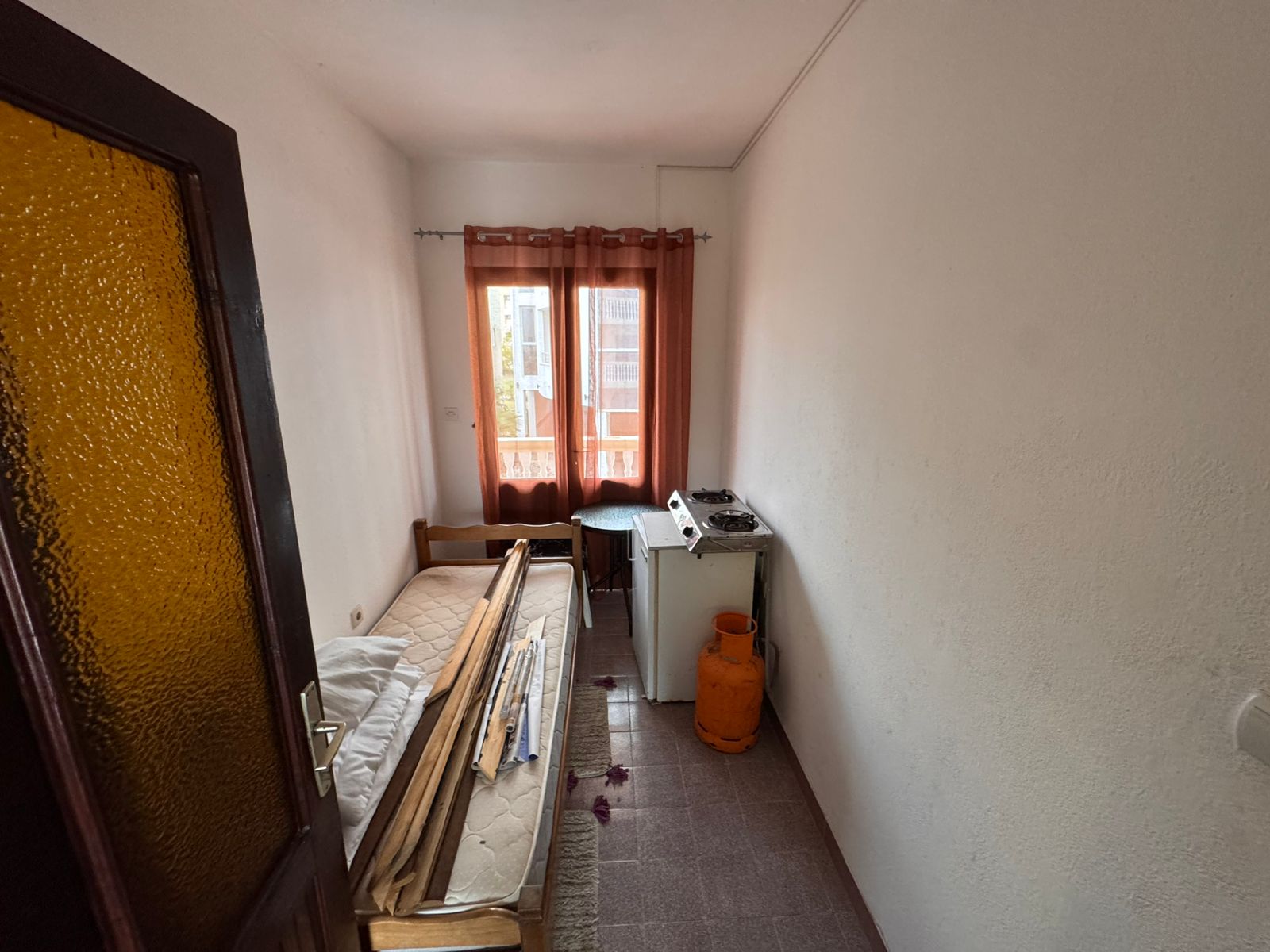 Bright, compact room in Ulcinj with bed, stove, and window—ideal Montenegro investment. Listed on montenegro-listings.me by ekosphere doo.