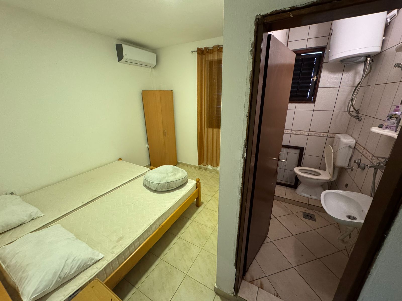 Modern Ulcinj room with twin beds, AC, tile floors, and en-suite bath—an ideal Montenegro property by ekosphere doo. Invest today!.