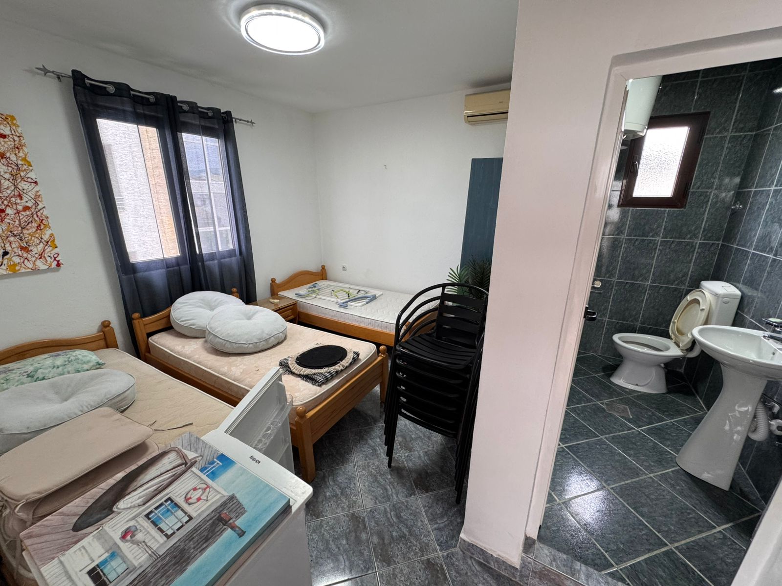 Cozy Ulcinj investment: compact room with twin beds, window, A/C, ensuite green-tiled bath. See more on montenegro-listings.me by ekosphere doo!.